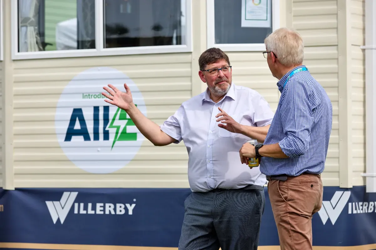 Peter Munk, CEO of Willerby discusses the new All-E system. In the background is a static caravan with a large All-E sticker. 