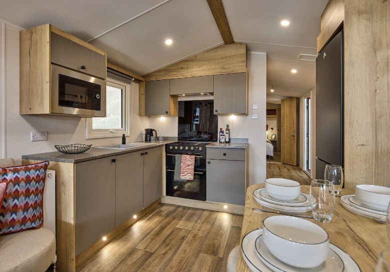 The Willerby Rio Compact kitchen has oak effect kitchen storage units with light grey cupboards and worktops.