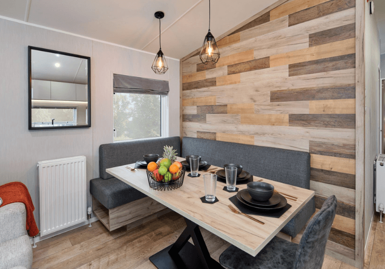The Willerby Astoria dining area with L-shaped fixed grey seating and an assortment of coloured wood effect feature wall.