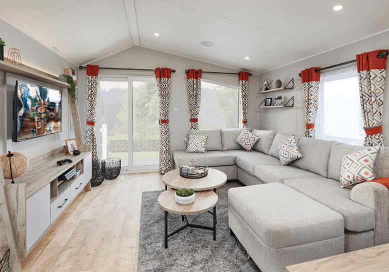 The Willerby Astoria lounge with an L-shaped freestanding comfy sofa, a round coffee table and a matching oak effect media unit.