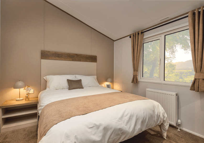 The Willerby Boston minimalist master bedroom with champagne accent wall and bedside tables.