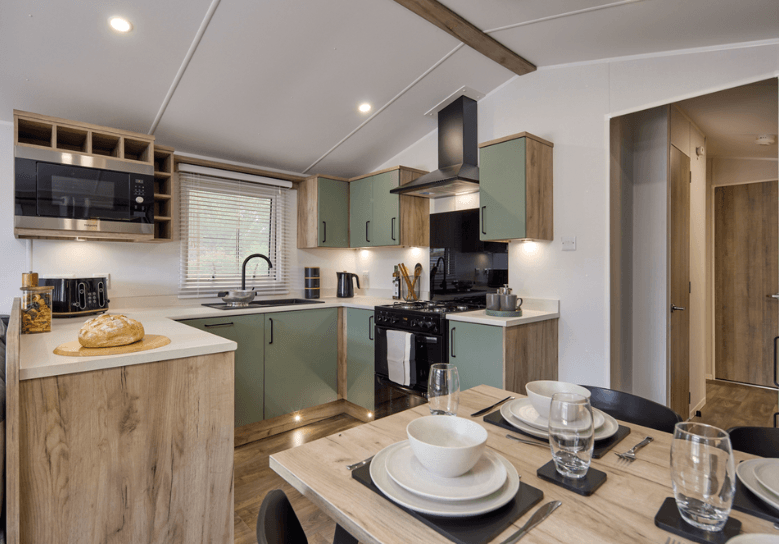 The kitchen-diner of the Willerby Buxton holiday home. There's plenty of space with a green and cream colour scheme. 