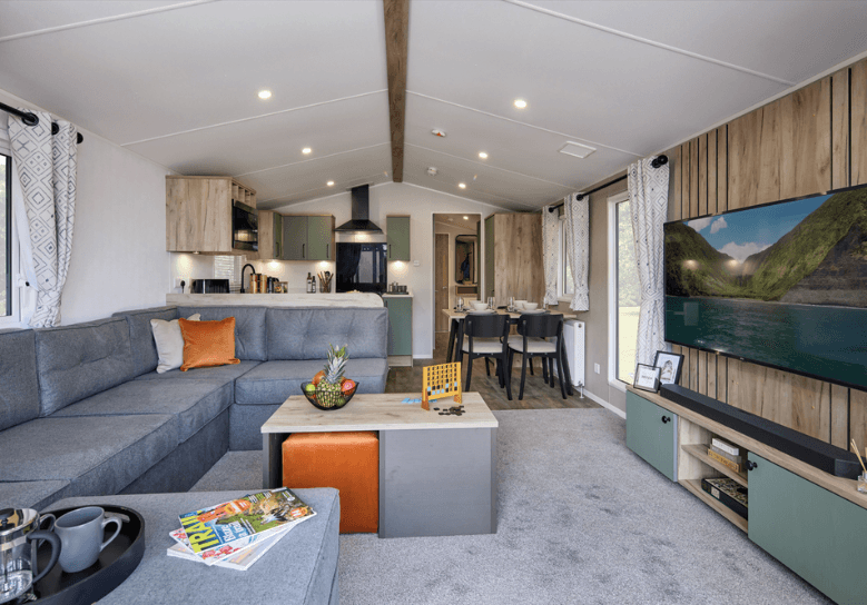 The living room of the Willerby Buxton holiday home. There is plenty of comfortable seating and a large feature media unit with TV. 