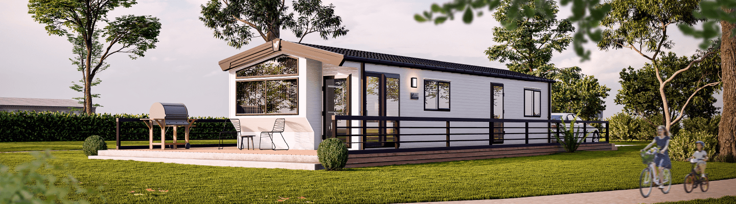 The Willerby Castleton exterior in white with brown decking sited on a grassy park.