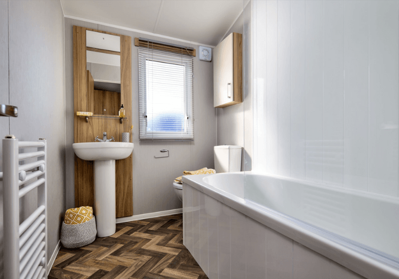 The Willerby Castleton bathroom with an oak effect storage unit and a patterned flooring.