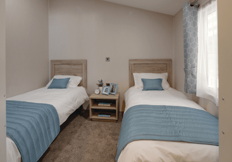 The Willerby Clearwater spacious twin bedroom with an oak effect side table and a matching oak effect headboard.