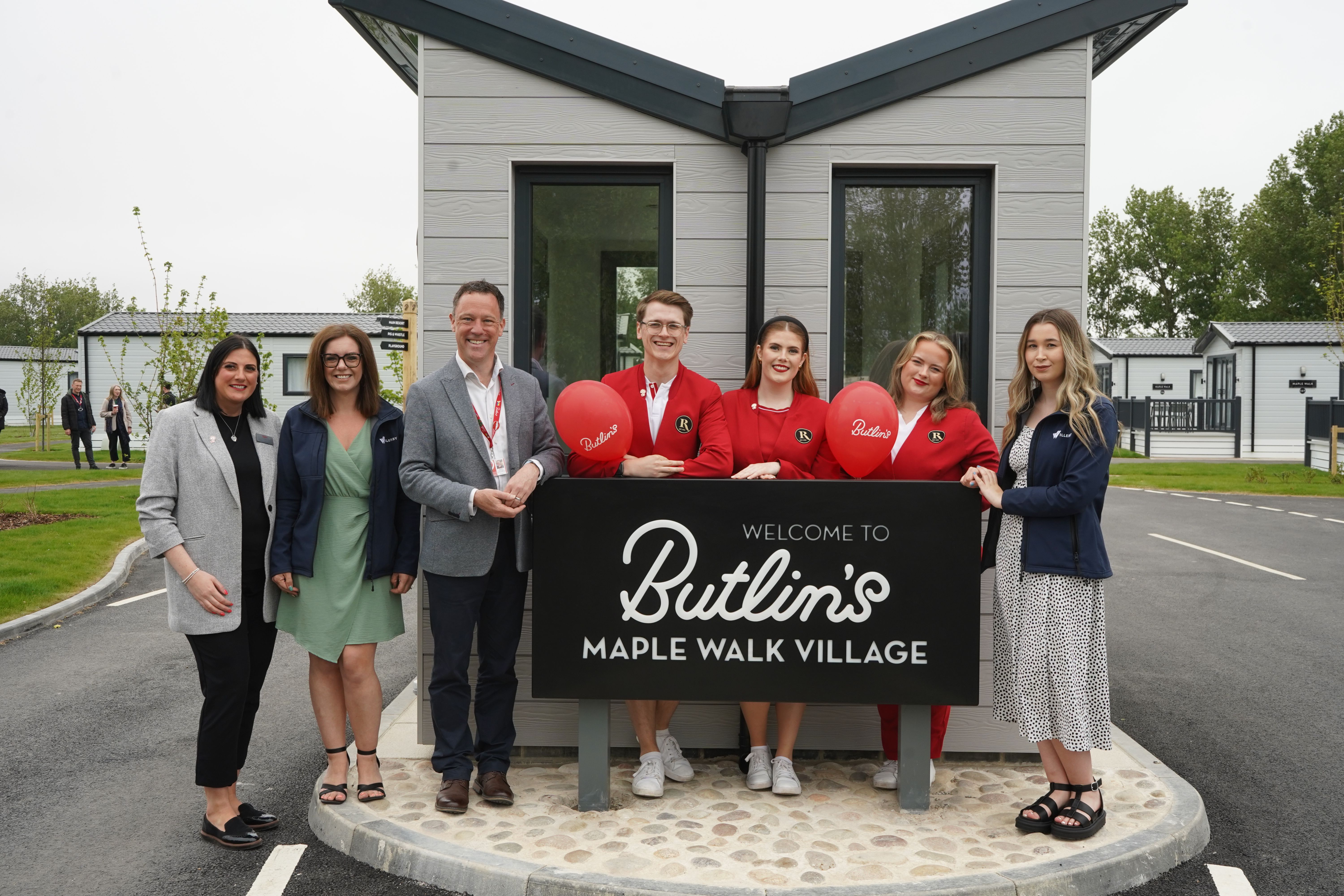 Willerby and Butlin's staff by the welcome sign at the new Maple Walk Village.