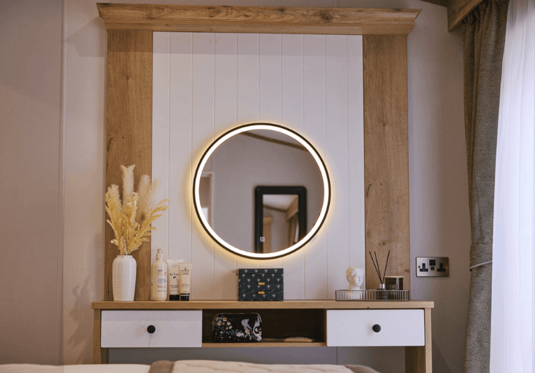 Dorchester dressing area with LED mirror and small white drawers in an oak unit.
