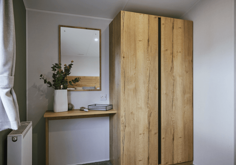 Ellerton dressing area with oak units and a square mirror.