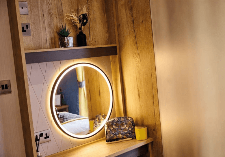 Gainsborough dressing area with an LED mirror and open oak storage.