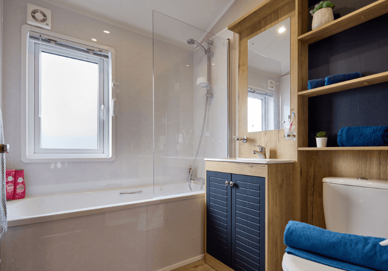 New Holland bathroom with oak and deep blue units and a bathtub.
