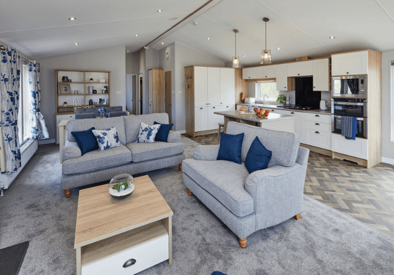 The Willerby Pinehurst lounge has two grey freestanding sofas with a oak effect coffee table in the center.