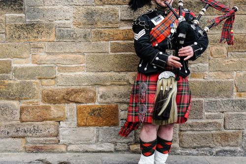 Man in kilt and playing bagpipes in Scotland