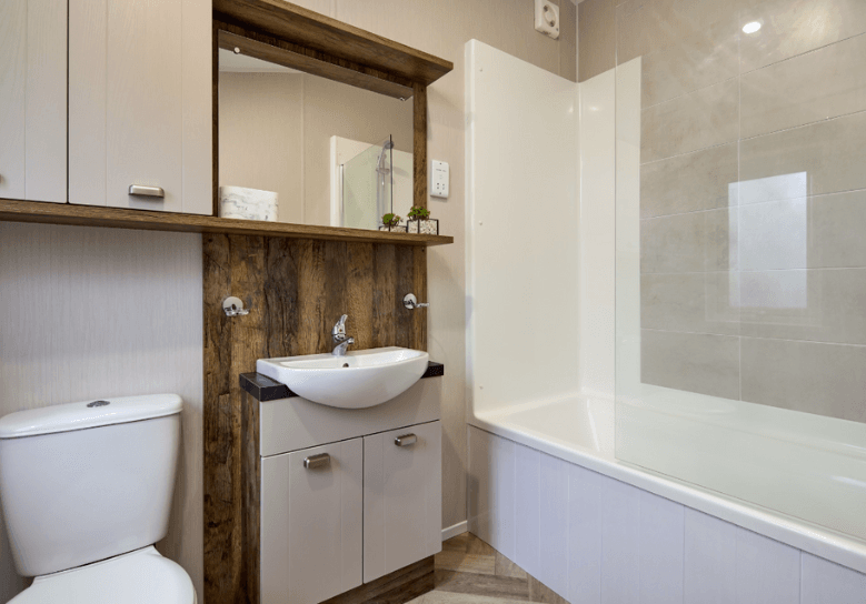 Sheraton ensuite with dark oak units with white cupboard doors and a bath tub.