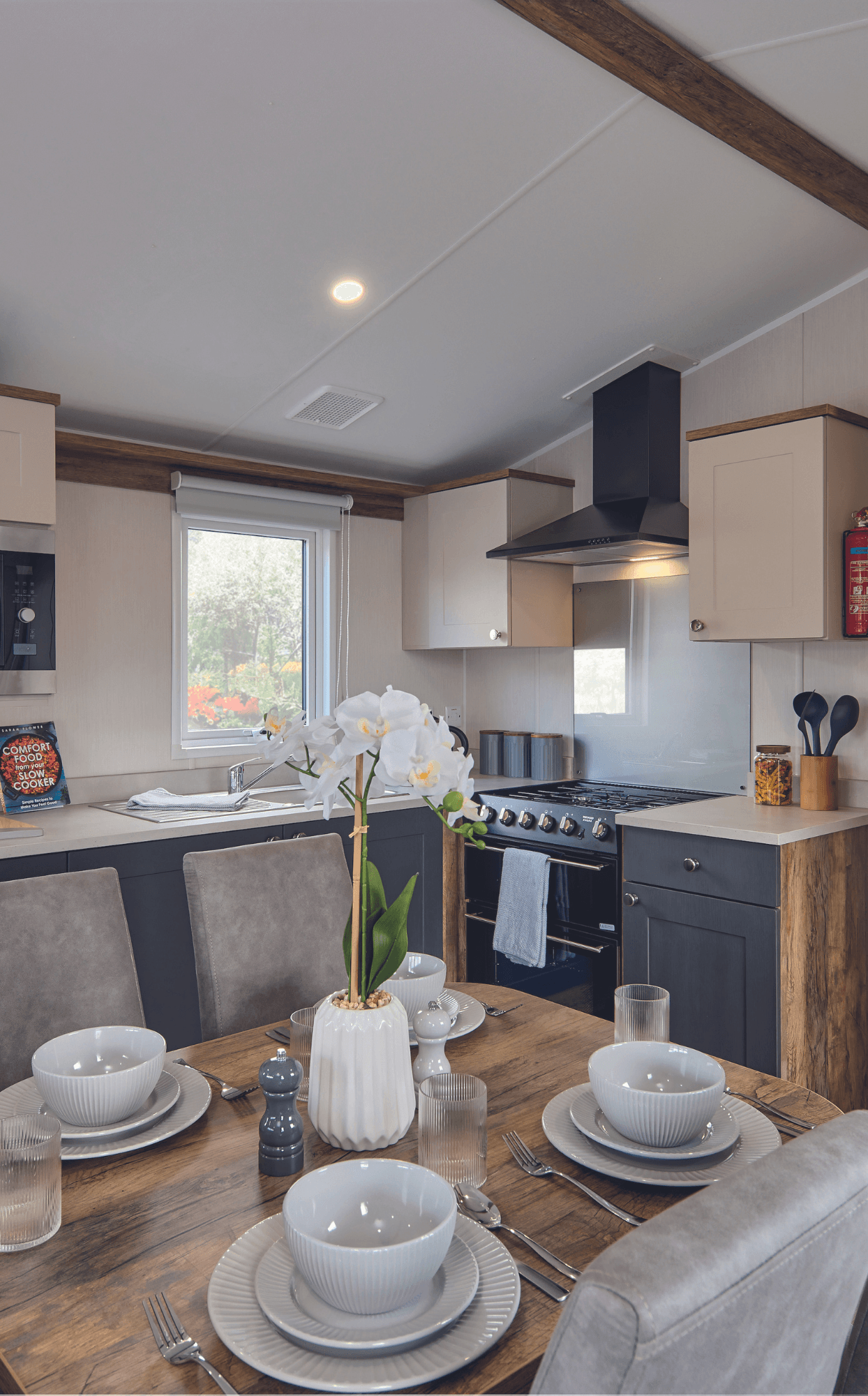 The Willerby Malton kitchen has cream and grey cupboard doors with a matching cream worktop.