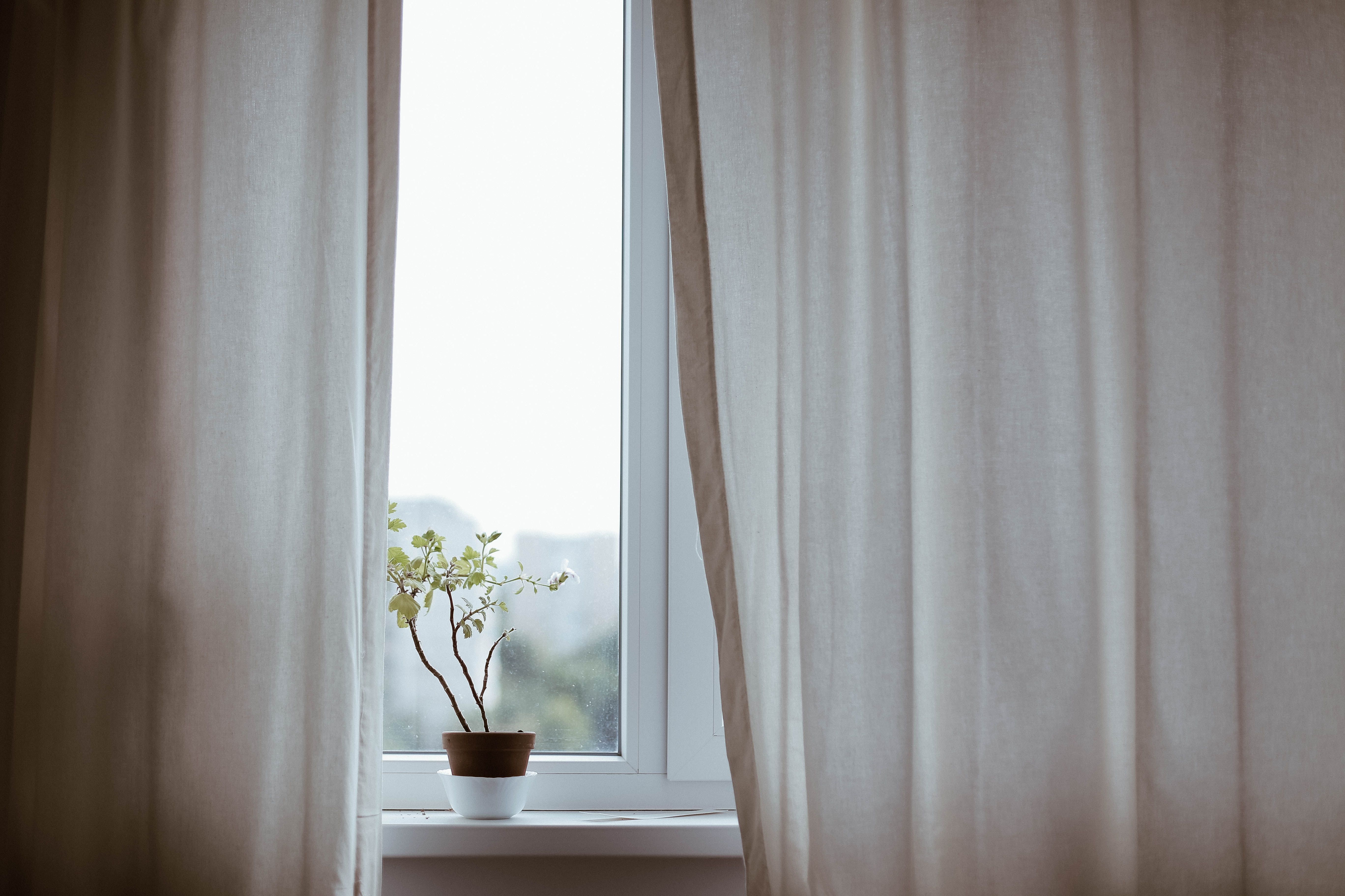 Thermal curtains covering a caravan window on a grey afternoon