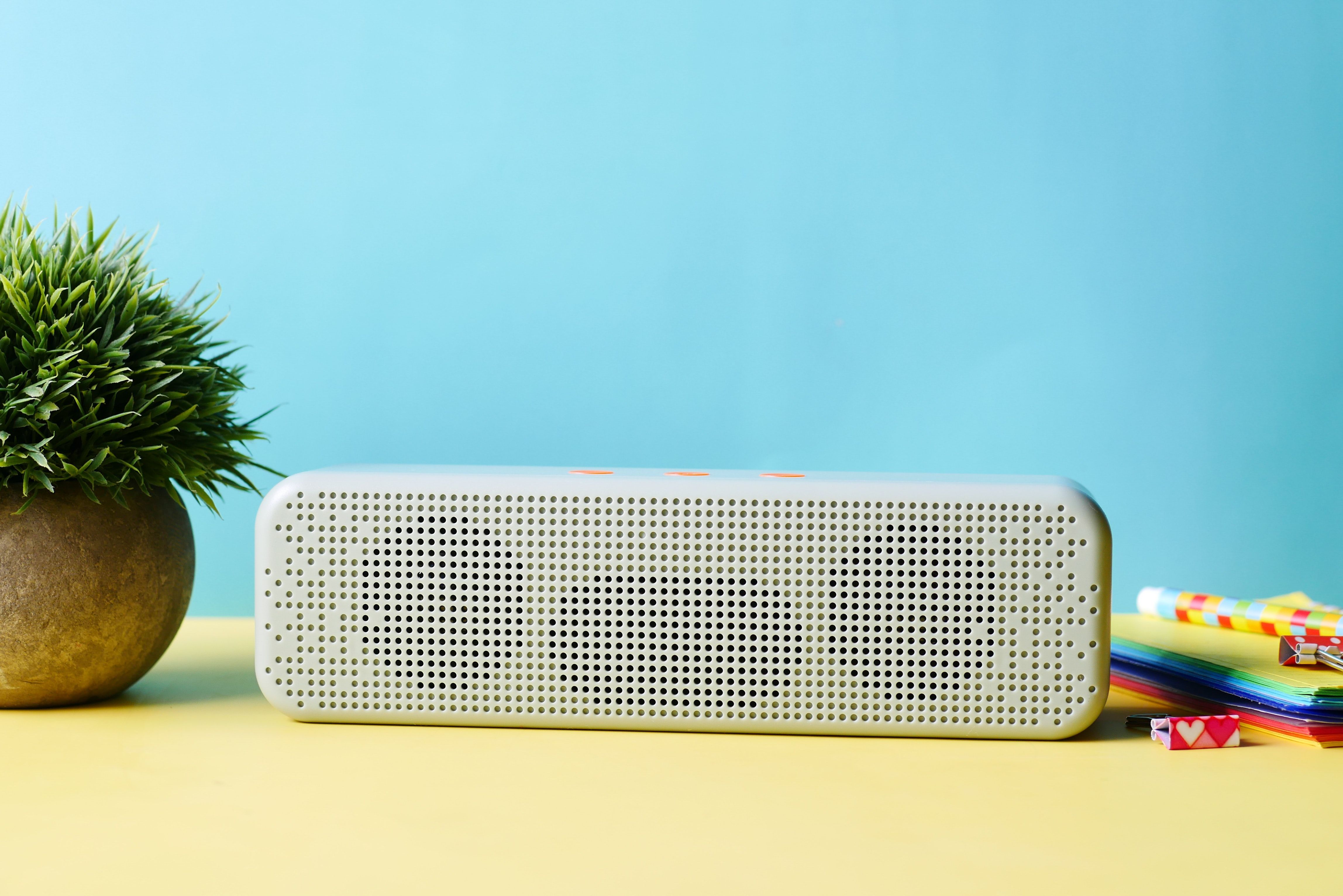 Small white Bluetooth speaker playing music in a static caravan