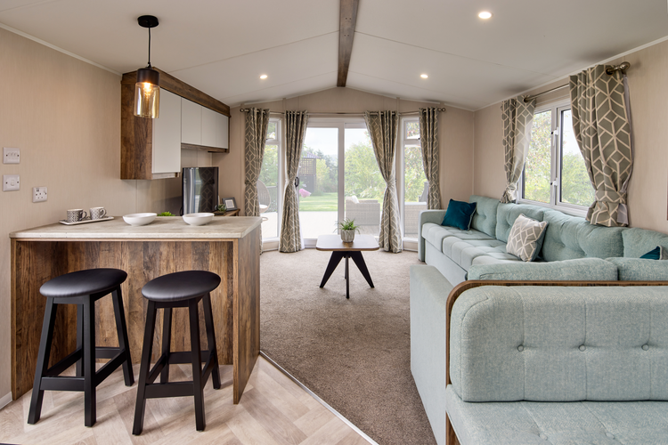 The Willerby Brookwood Breakfast bar with black stools and a dark oak effect table with white marble effect tabletop.