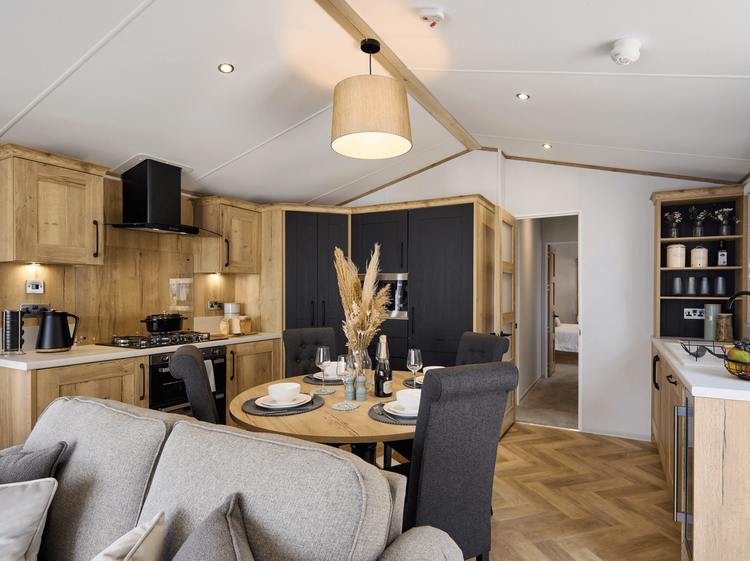 The Willerby Dorchester luxurious kitchen with oak effect kitchen cabinets and black cupboard doors, and plenty of worktop space.