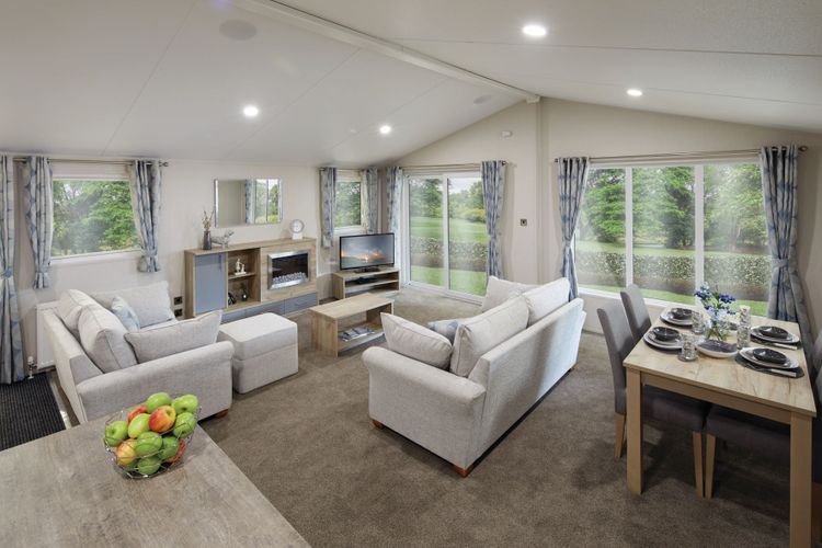 The Willerby Clearwater view of the open plan layout lounge and the dining area, with plenty of windows allowing light in.