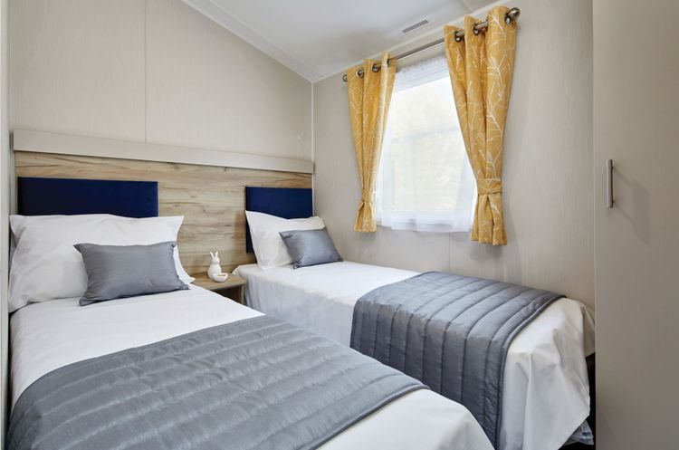 The Willerby Linwood twin bedroom has upholstered dark blue headboards.