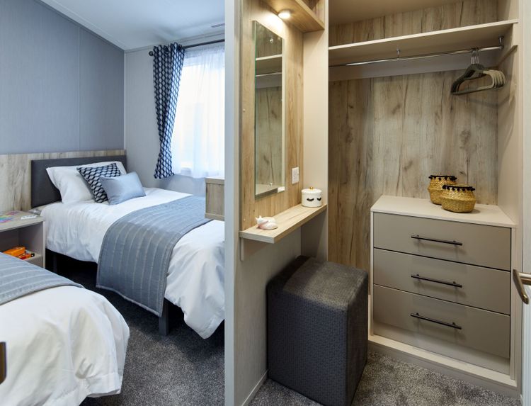 The Willerby Mapleton twin bedroom has an open dressing area as you walk into the room with matching oak effect bedside tables.