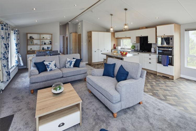 The Willerby Pinehurst lounge has two grey freestanding sofas with a oak effect coffee table in the center.