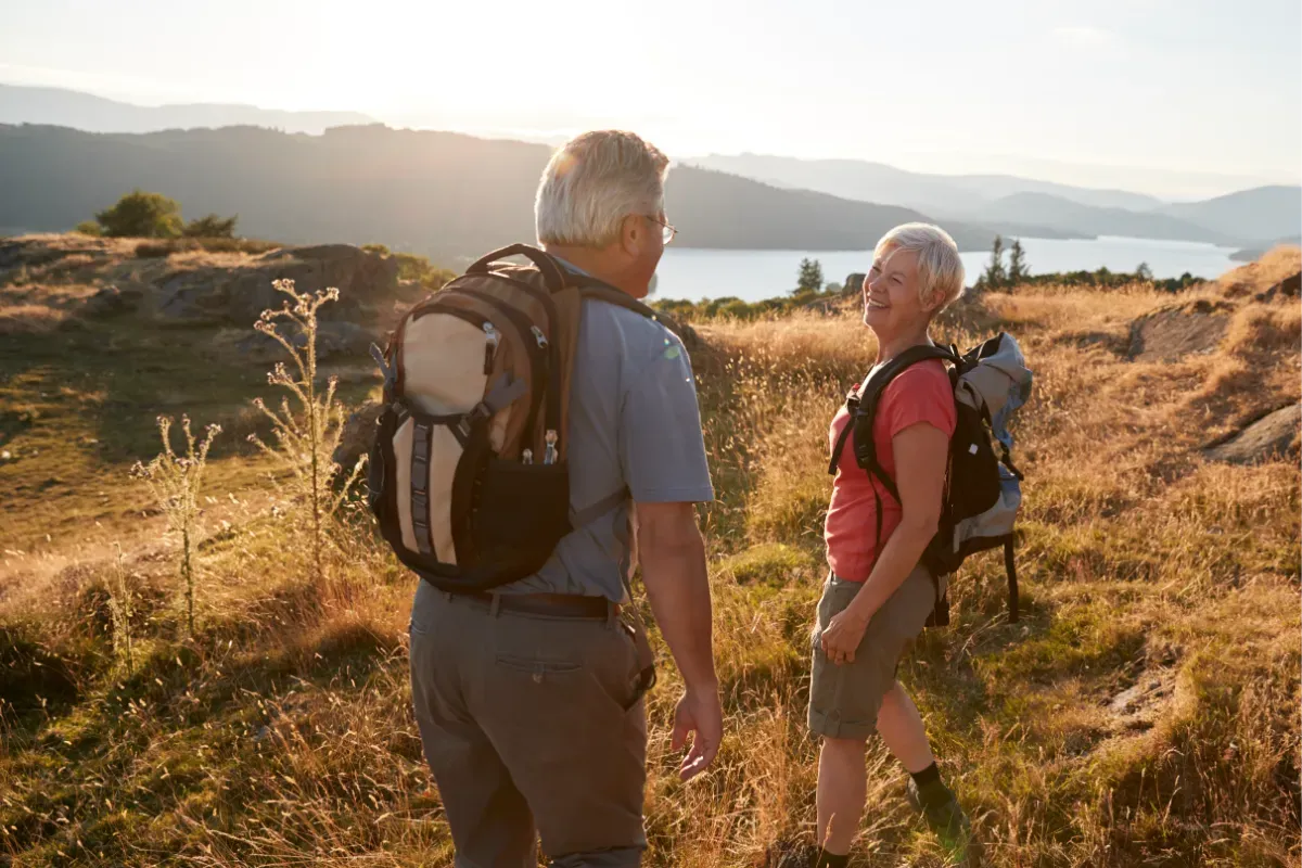 A couple hiking in the hills above a lake in the Lake District.